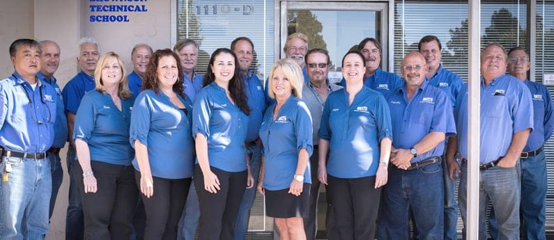 18 members of the Brownson team in front of the H V A C school for a group shot