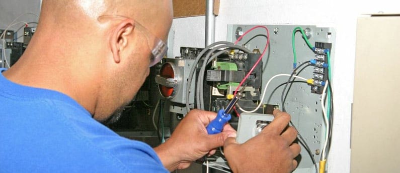 An H V A C student working on an electrical component for the classroom portion of blended learning